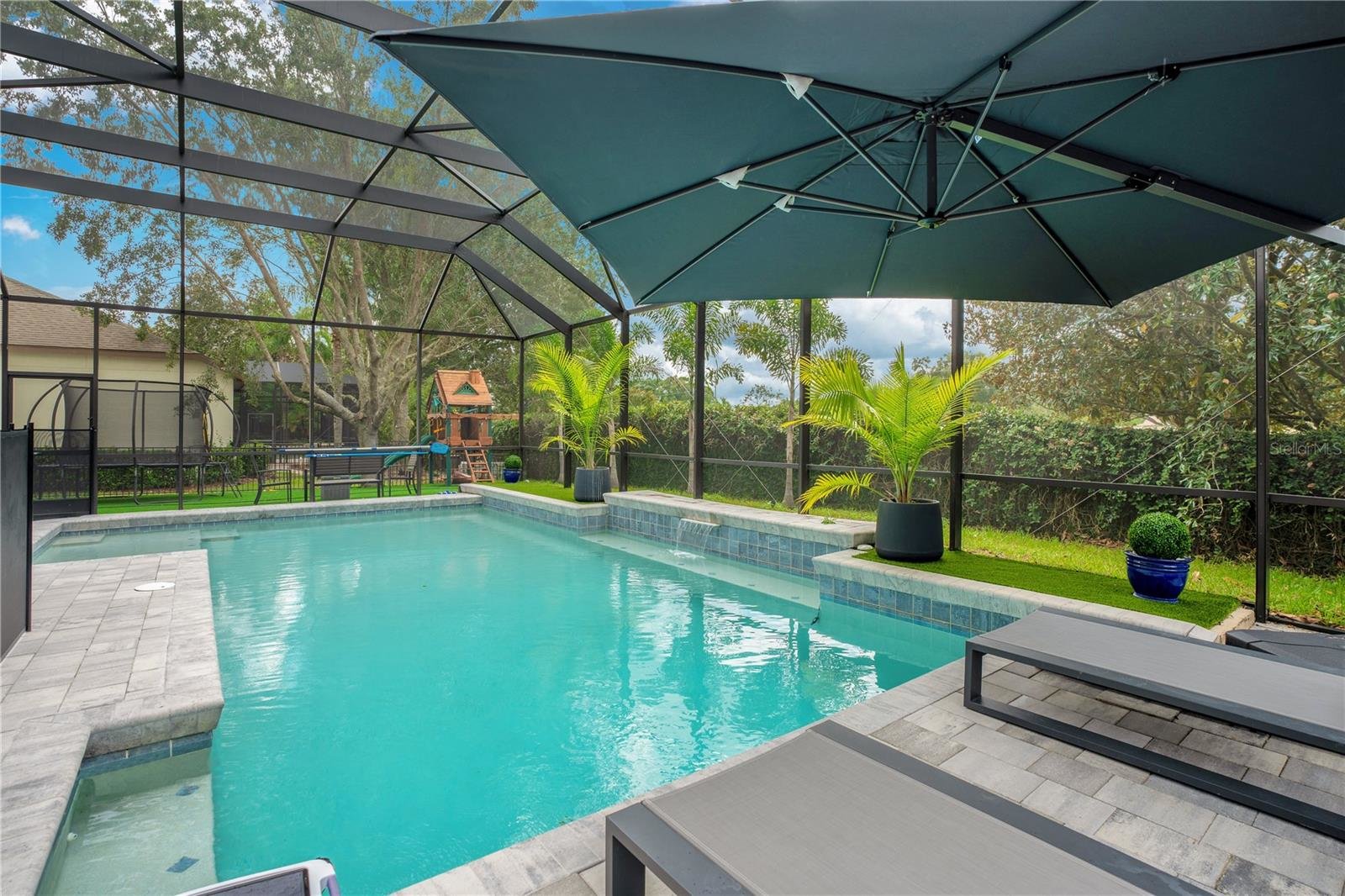 large pool with yard and trampoline in background